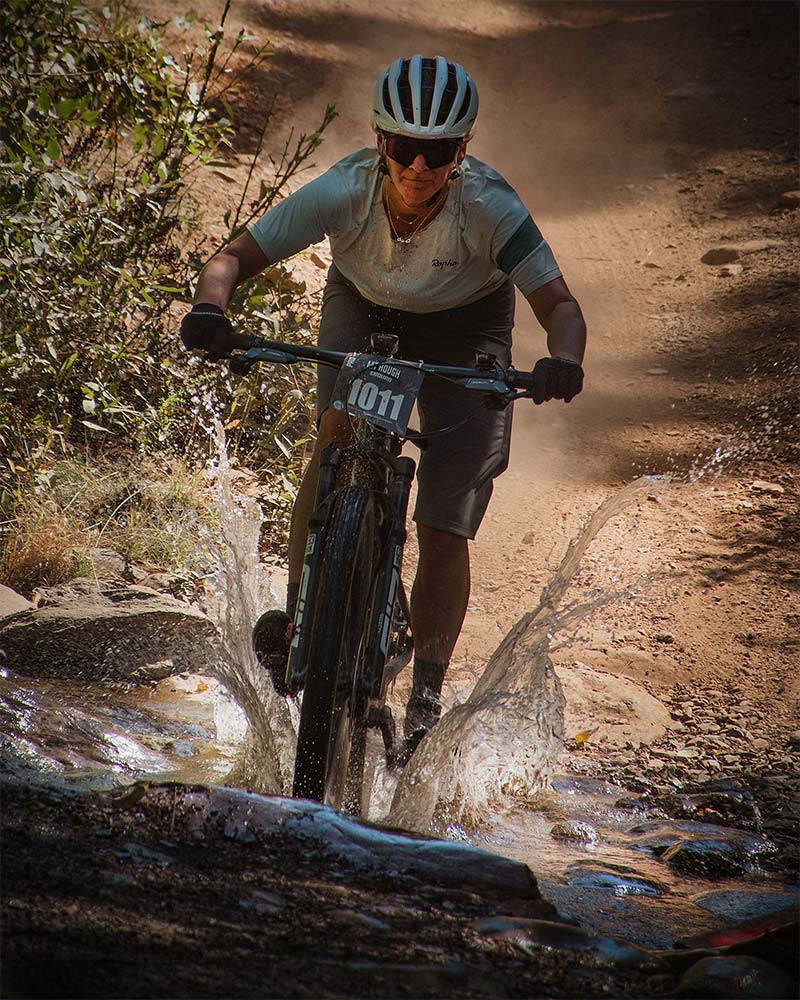 Enduro racer splashing through a stream