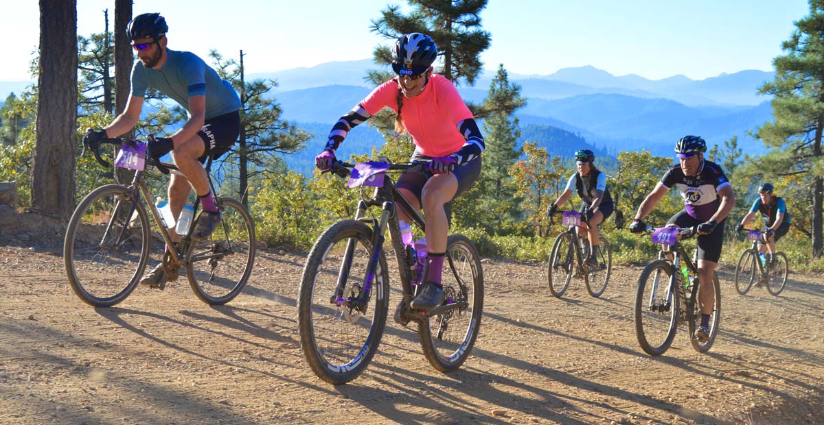 Gravel Grinder racers smiling and riding up mountains