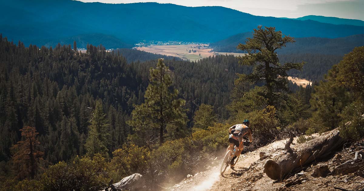 Enduro mountain bike racer with Quincy in the background