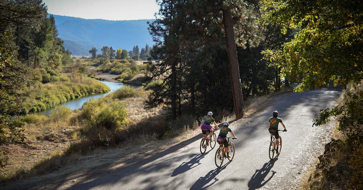 Grinduro gravel bike racers riding through a mountain valley